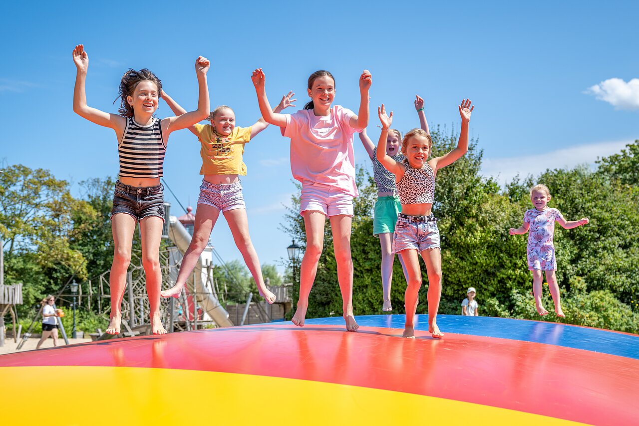 Enfants sautant sur un trampoline gonflable g�ant au camping CAPFUN De Pekelinge � Oostkapelle.
