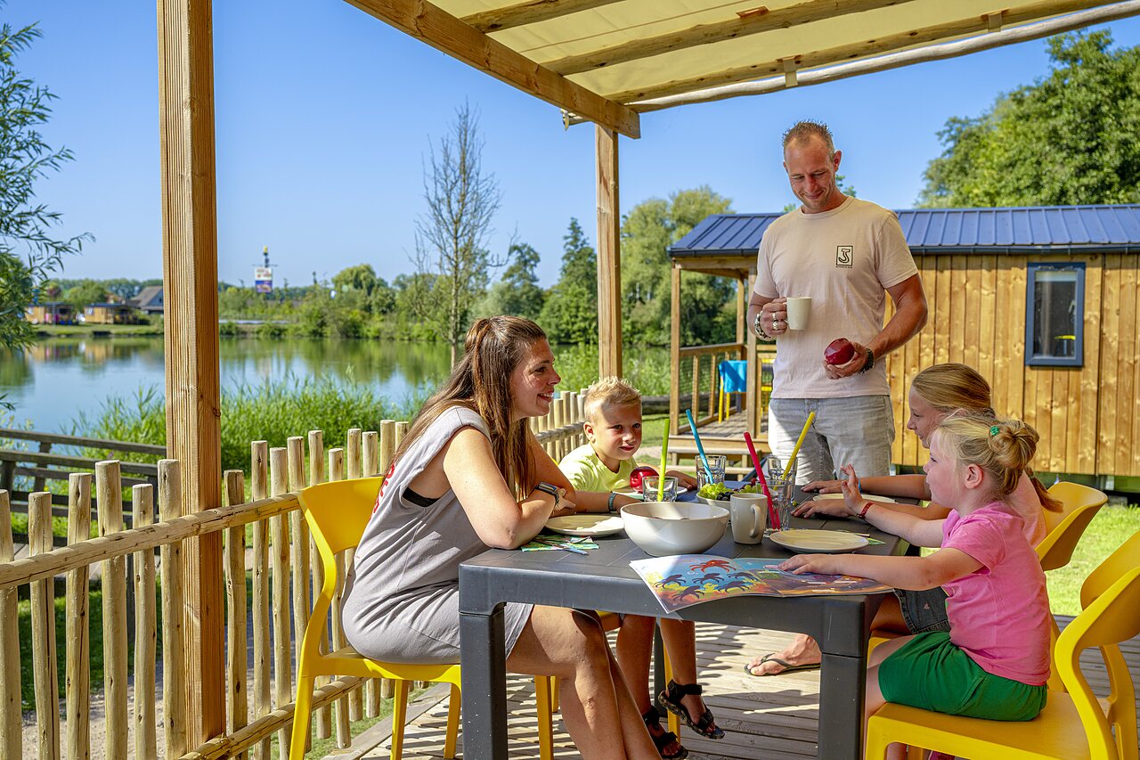 Famille sur terrasse Mobil-home, vue lac, au camping CAPFUN De Rotonde � Enspijk.