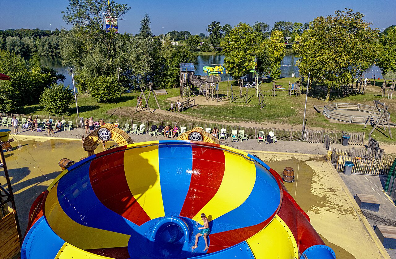 Grand toboggan aquatique color�, aire de jeux et lac au camping CAPFUN De Rotonde � Enspijk.
