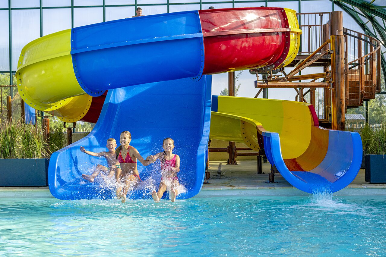 Toboggan aquatique color� et enfants dans la piscine au camping CAPFUN De Rotonde � Enspijk.