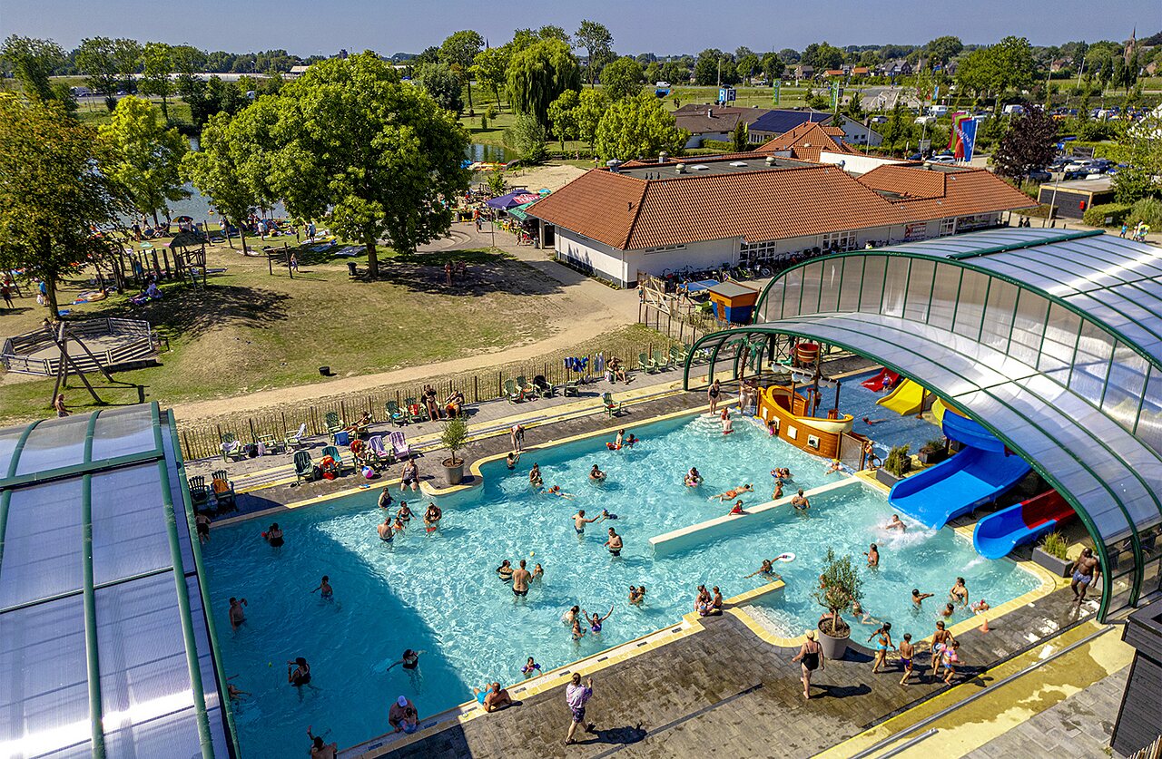 Piscine couverte, toboggans aquatiques et lac vus du ciel au camping CAPFUN De Rotonde � Enspijk.