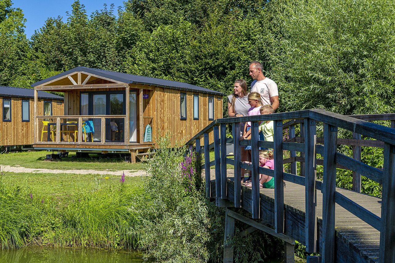 Famille sur pont en bois pr�s de Mobil-homes au camping CAPFUN De Rotonde � Enspijk.