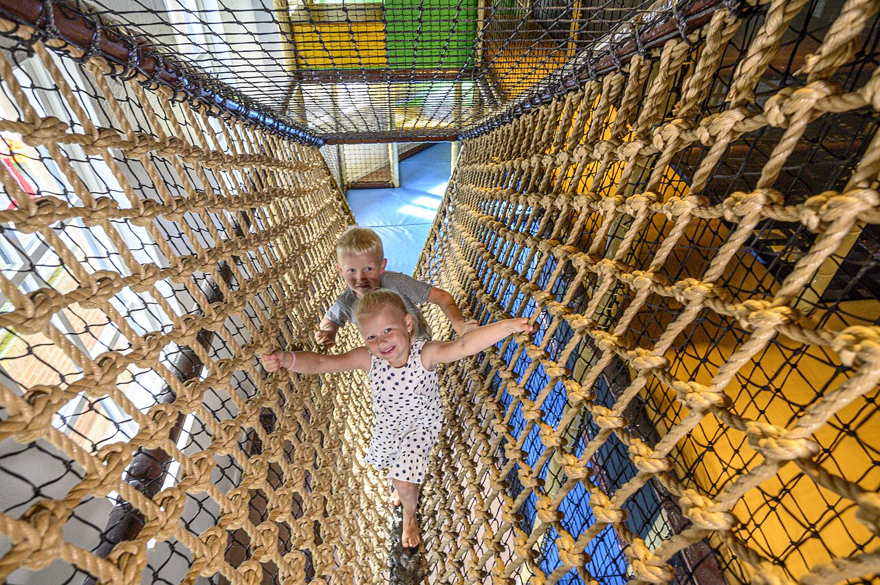 Enfants jouant dans un tunnel de cordes au camping CAPFUN De Scheepsbel � Doornspijk.