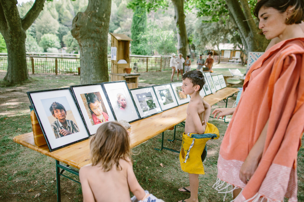 Enfants regardant une exposition de photos en plein air au camping LIBRANOO Naturiste Belezy � B�doin (84).