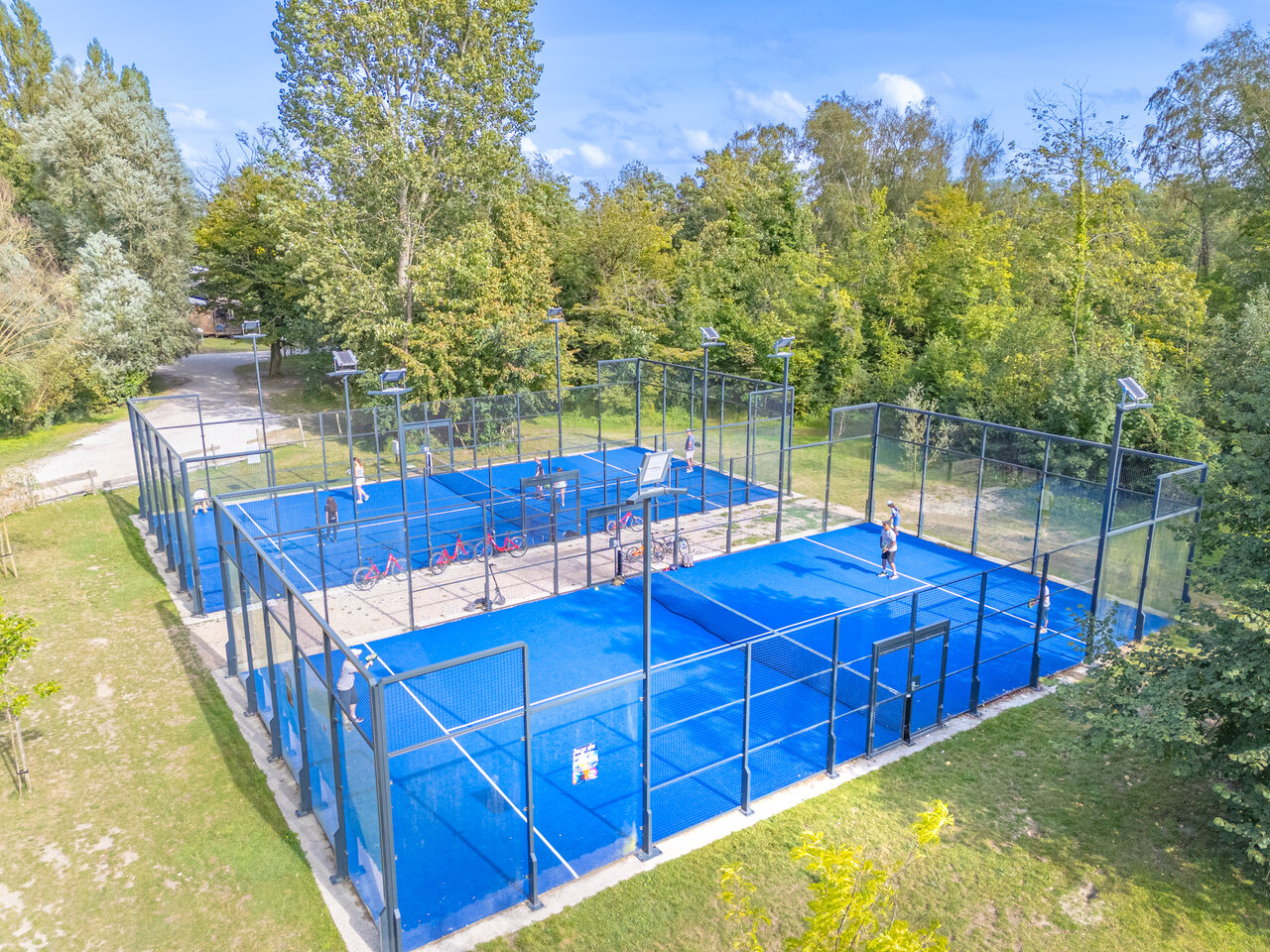 Terrains de padel bleus ext�rieurs avec joueurs au CAPFUN Dune Fleurie, Quend Plage (80).