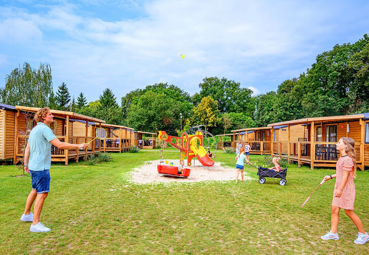 Famille jouant badminton et enfants au parc de jeux, h�bergements en bois au camping CAPFUN Eibernest � Eibergen.