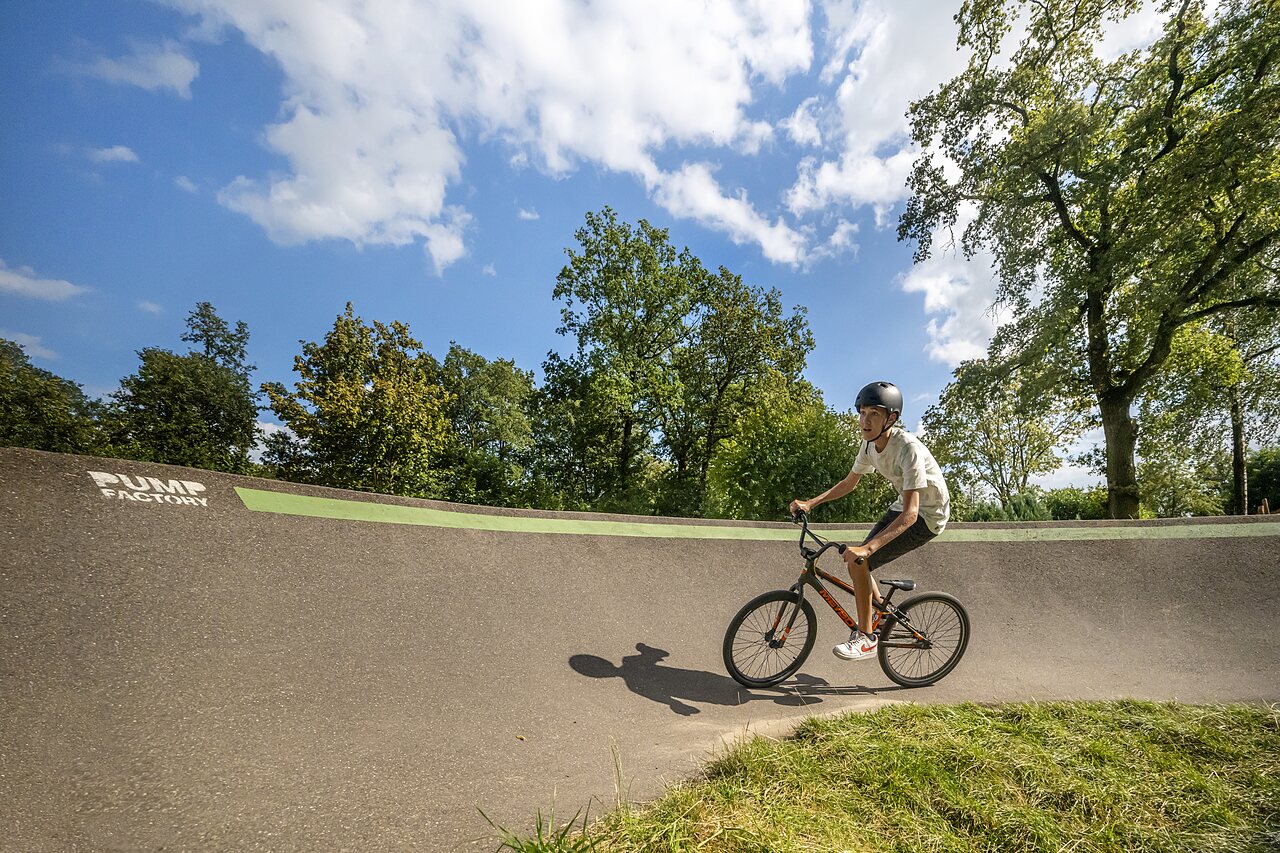 Jeune cycliste sur un pump track avec BMX au camping CAPFUN Eibernest � Eibergen.
