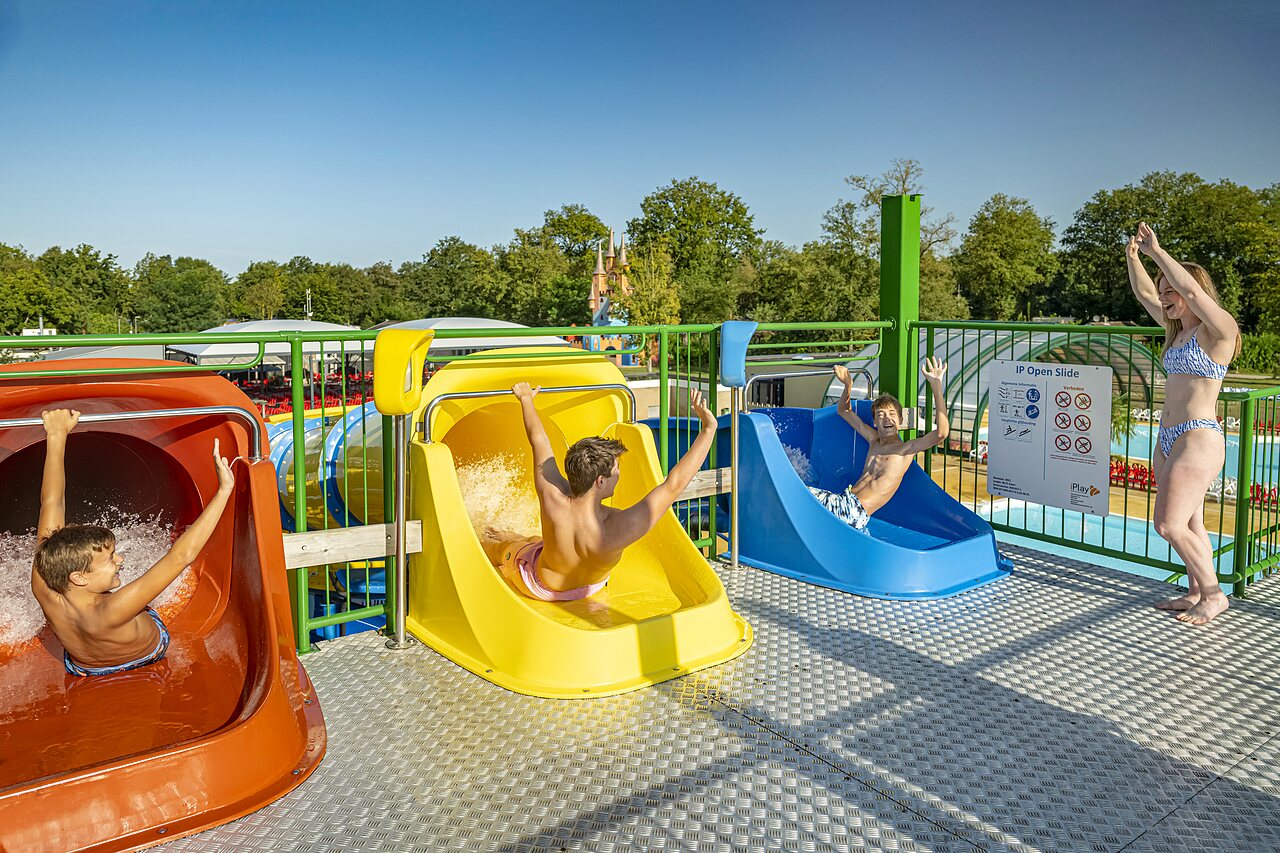 Enfants et adultes s'amusant sur les toboggans aquatiques color�s au camping CAPFUN Eibernest � Eibergen.