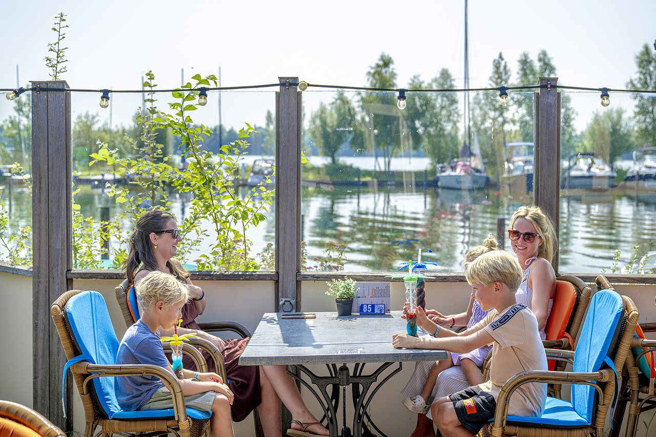 Famille au bar, boissons rafra�chissantes, vue sur le lac au camping CAPFUN Erkemederstrand � Zeewolde.