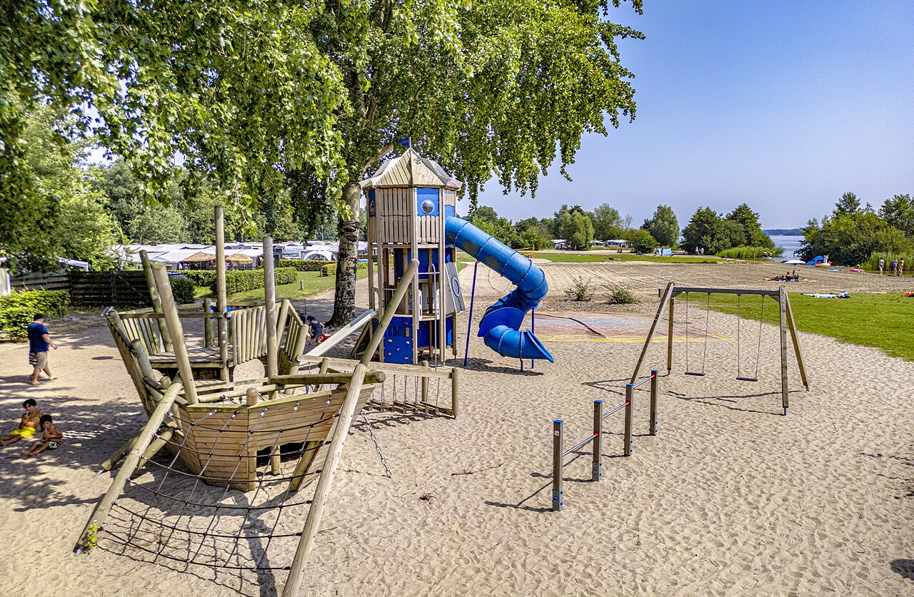 Aire de jeux avec toboggan, balan�oires et plage de sable au camping CAPFUN Erkemederstrand � Zeewolde.