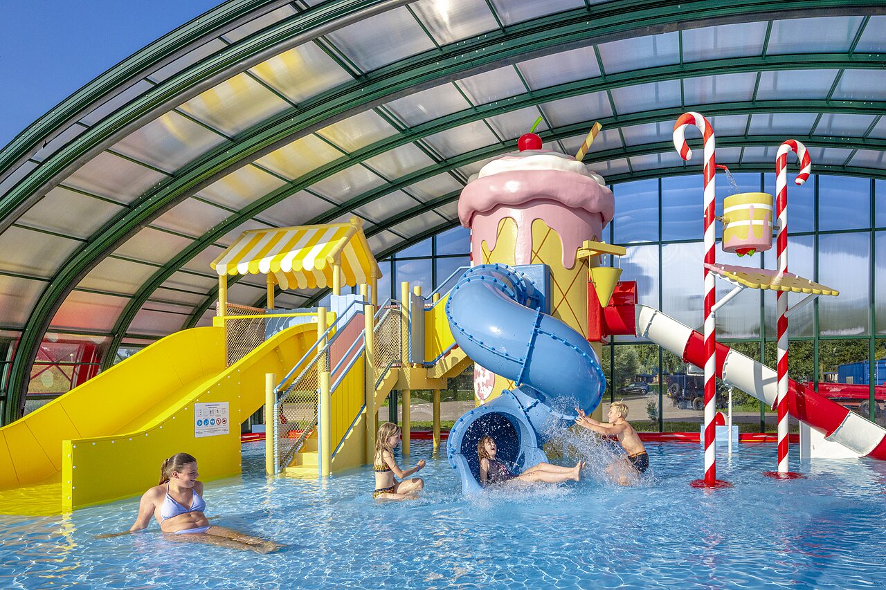 Piscine couverte avec toboggans et aire de jeux aquatique au camping CAPFUN Erkemederstrand � Zeewolde.
