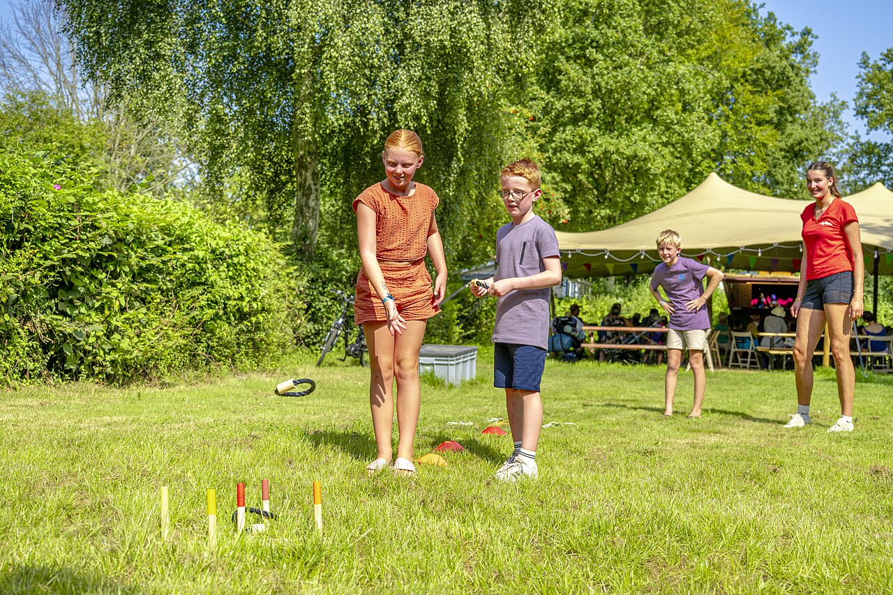 Enfants jouant au lancer d'anneaux sur l'herbe au camping CAPFUN Erkemederstrand � Zeewolde.