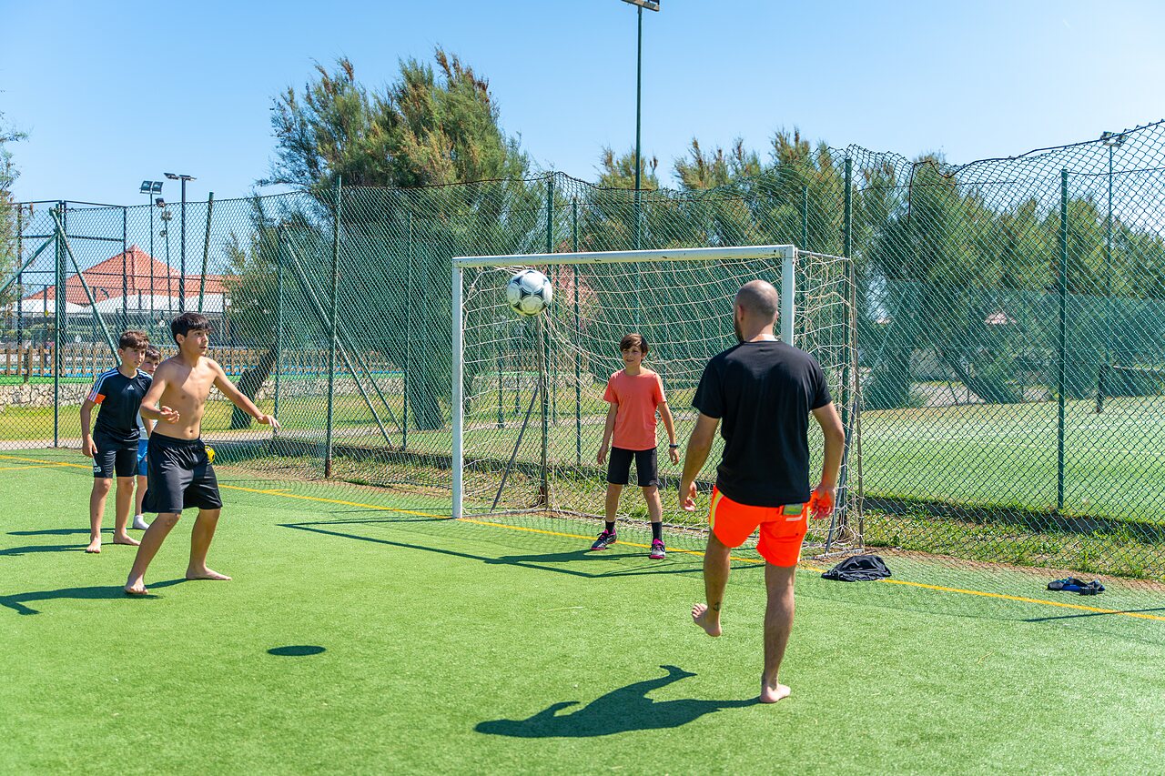 Terrain multisport avec des vacanciers jouant au football au camping CAPFUN Europing � Tarquinia (01).