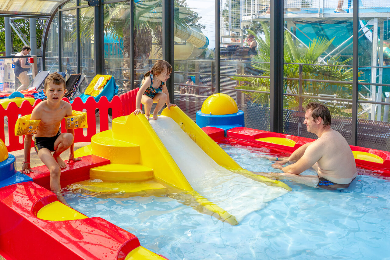 Piscine couverte, toboggan et jeux aquatiques pour enfants au camping CAPFUN L'Eve.
