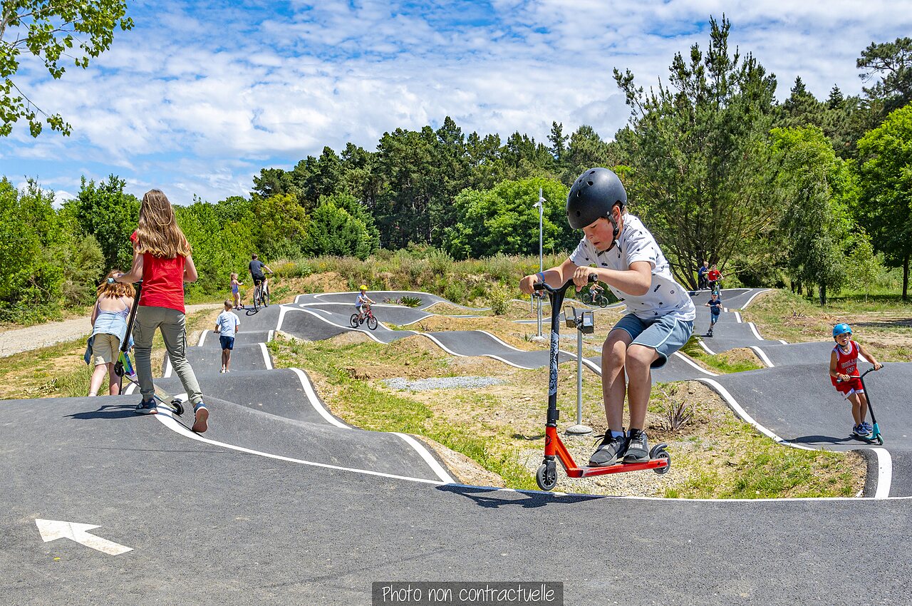 Piste de pumptrack avec enfants en trottinette et v�lo au camping CAPFUN Falaises � Gonneville sur Mer.