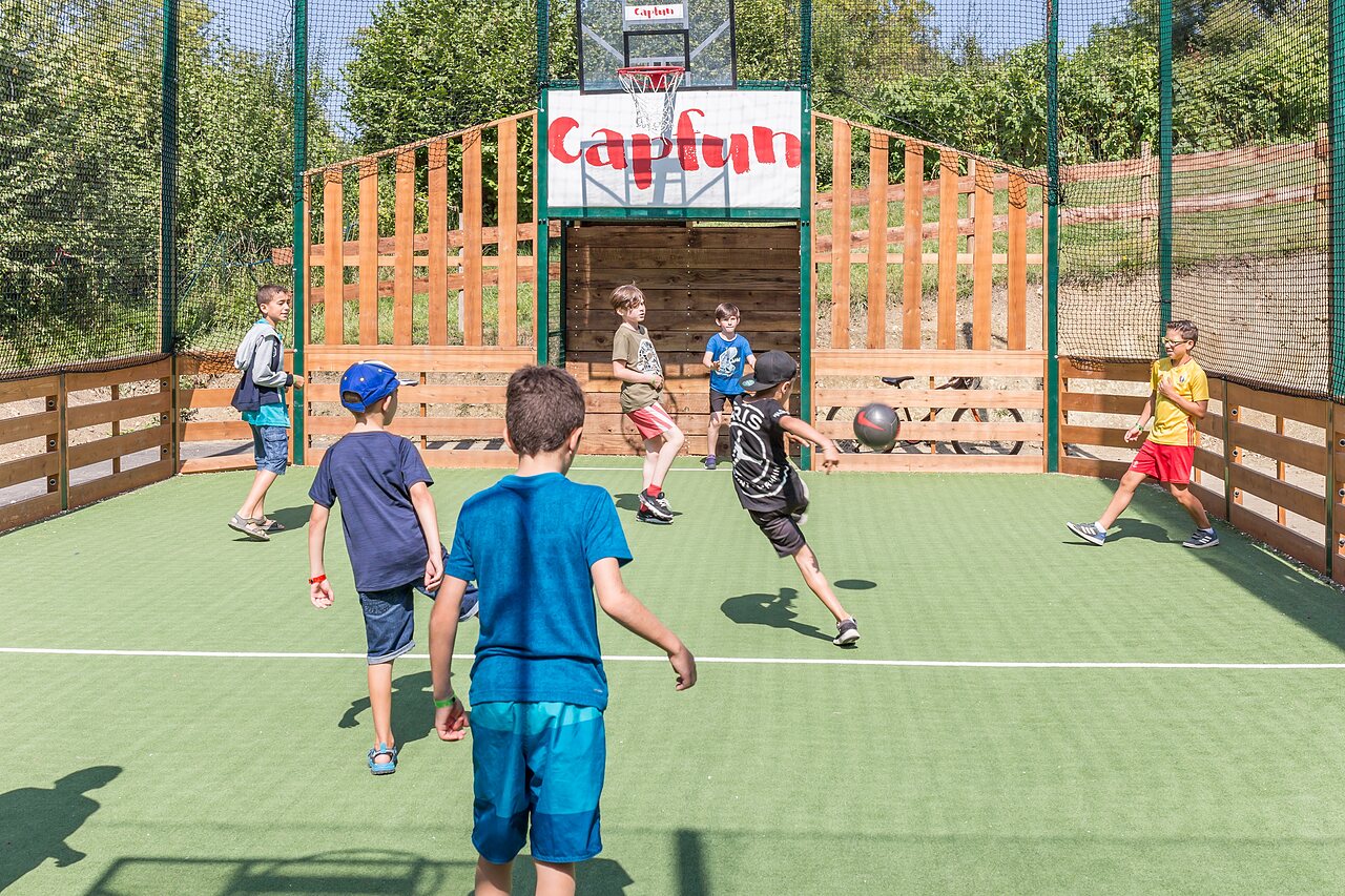 Terrain multisport avec enfants jouant au ballon au camping CAPFUN Falaises � Gonneville sur Mer.