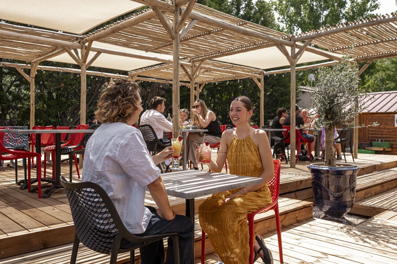 Terrasse de bar et restaurant, clients profitant de cocktails au camping CLICOCHIC Filament � Thoiras.