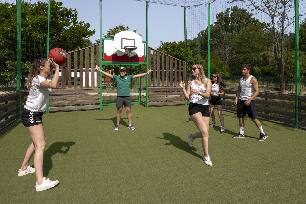 Terrain multisport avec jeunes jouant au basketball au camping CLICOCHIC Filament � Thoiras (30).
