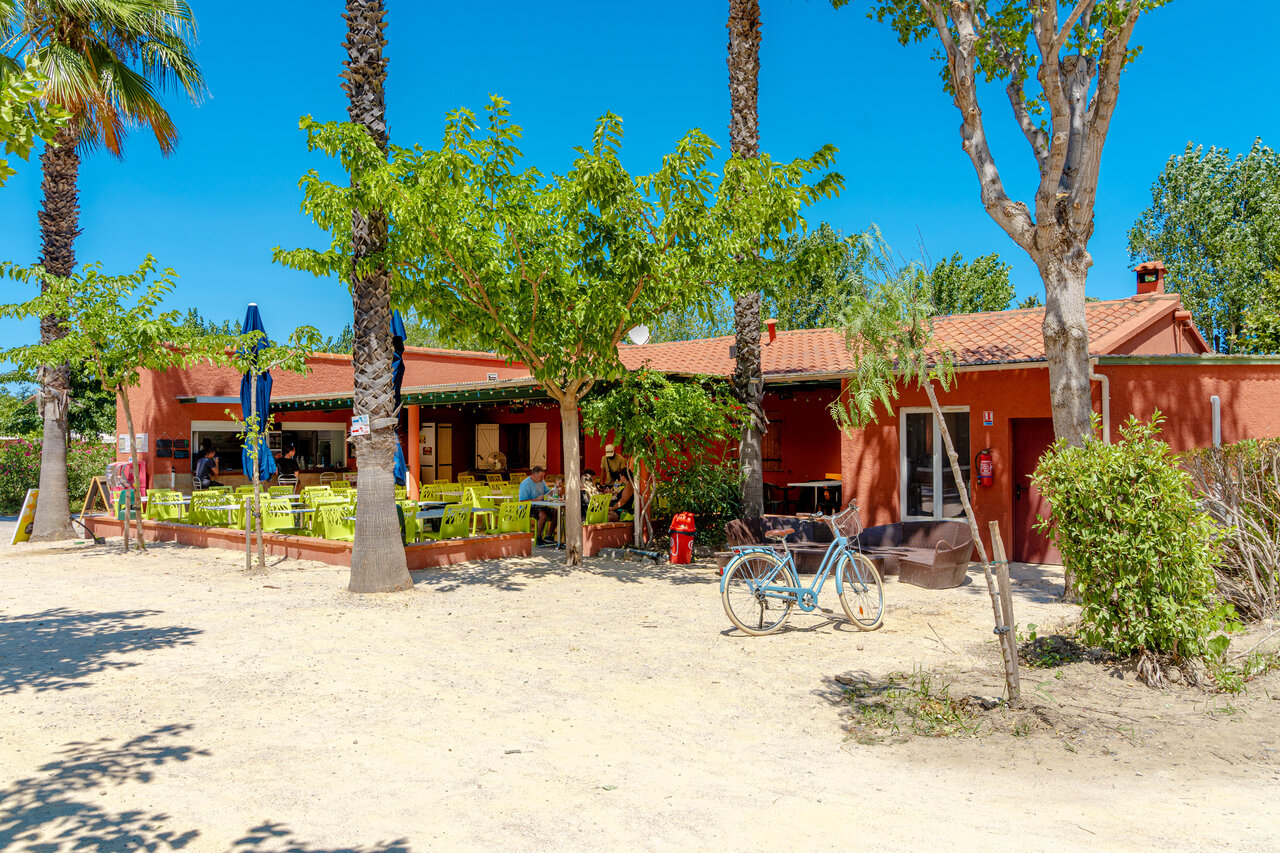 Restaurant-bar avec terrasse ext�rieure et palmiers au camping VAGUES OCEANES Au Flamenco � Argel�s-sur-Mer.