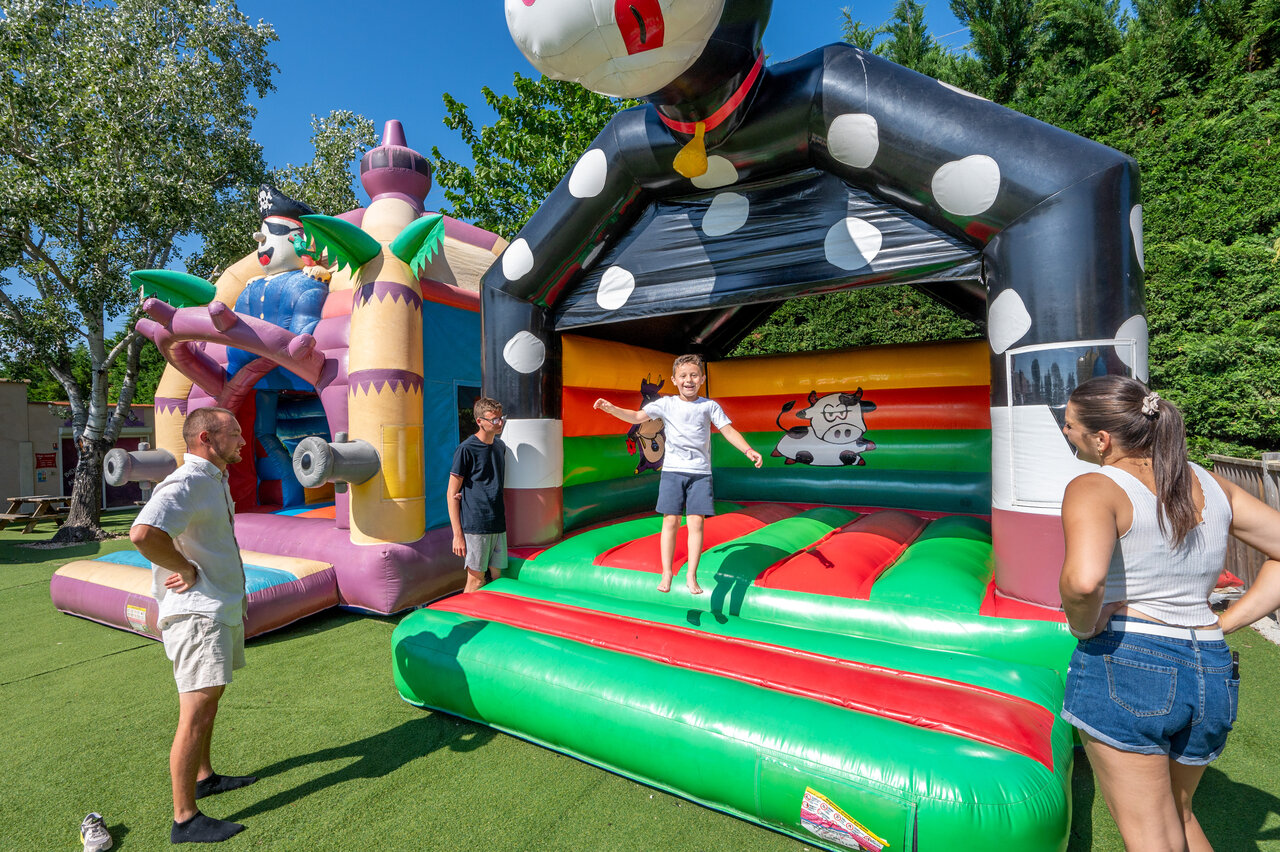 Enfants s'amusant sur ch�teaux gonflables color�s au camping CAPFUN Fleur de Camargue (30).