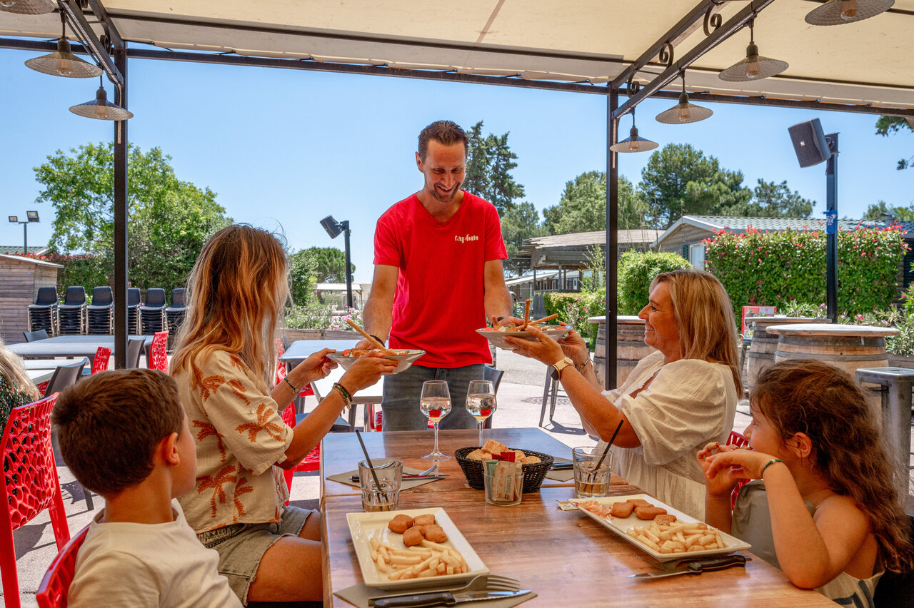 Restaurant Capfun, famille d�jeunant dehors au camping CAPFUN Fleur de Camargue � Saint-Laurent-d Aigouze.