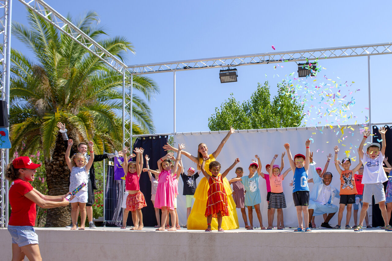 Enfants et animateurs joyeux sur sc�ne avec confettis au camping CAPFUN Fleur de Camargue � Saint-Laurent-d Aigouze (30).