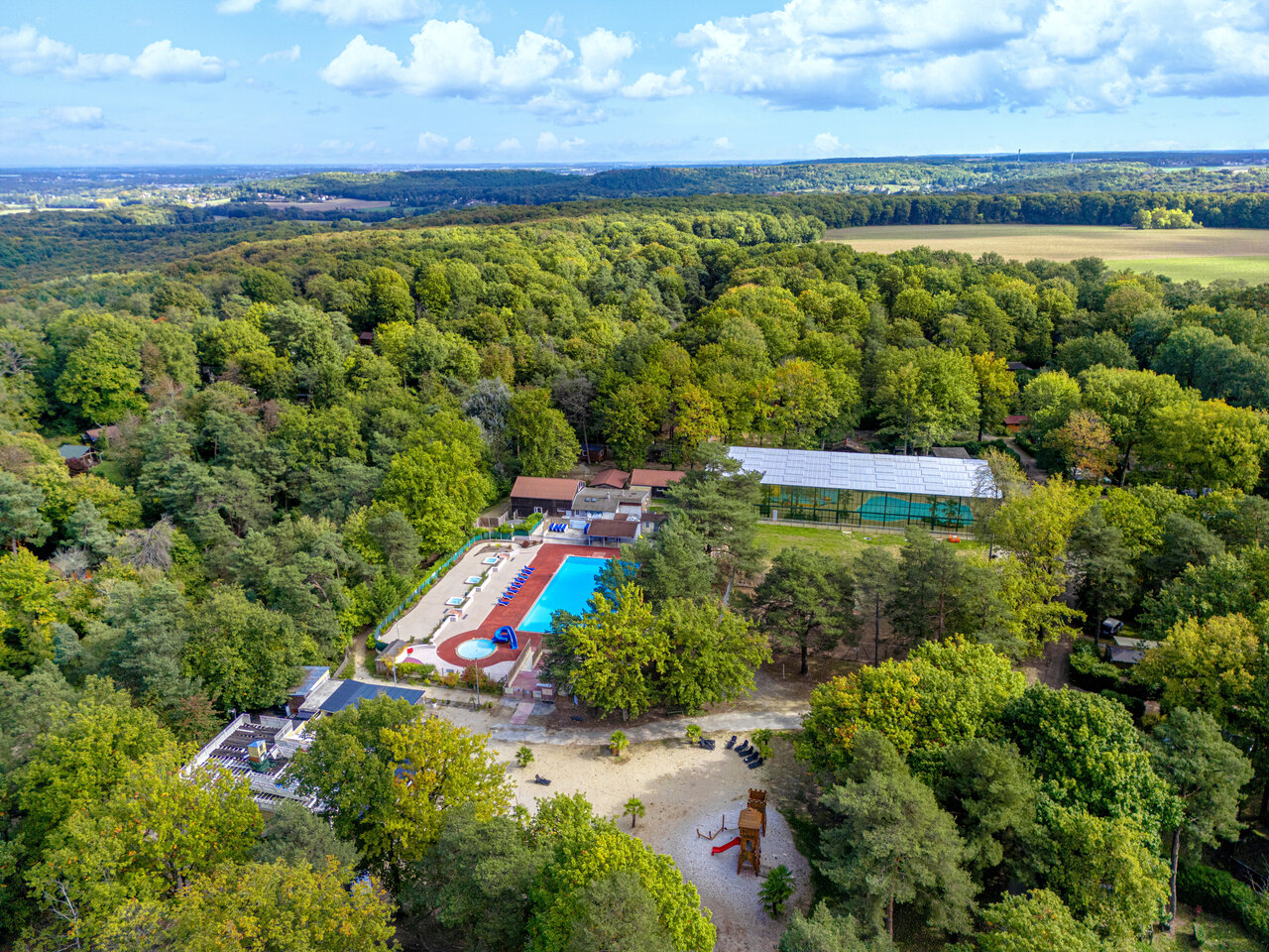 Aerial pools, forest at CLICOCHIC La For�t d'Azal�e campsite in Saint-Ch�ron.
