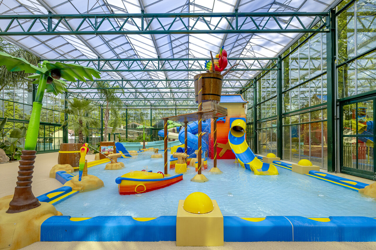 Covered water play area with slides and tipping bucket at CLICOCHIC La For�t d'Azal�e campsite in Saint-Ch�ron (91).