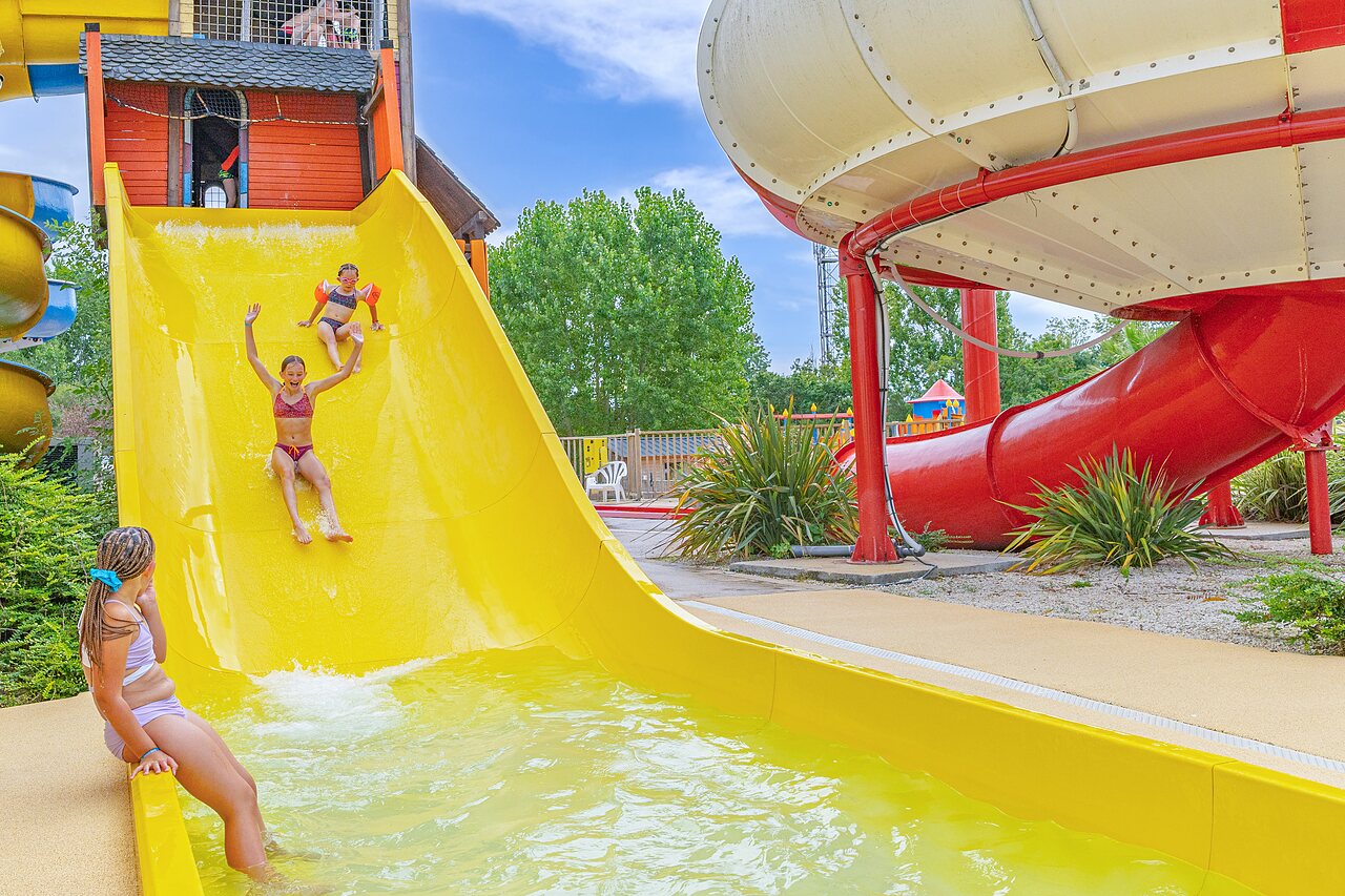 Toboggan aquatique jaune et piscine avec enfants au camping CAPFUN Forges � Avrille (85).