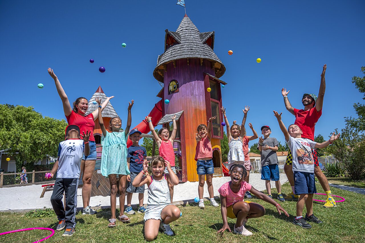 Enfants et animateurs jouant avec des balles sur l'aire de jeux au camping CAPFUN Forges � Avrille (85).