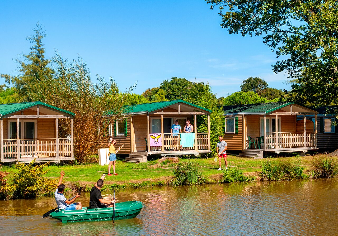 Chalets en bois au bord d'un �tang avec activit�s nautiques au camping CAPFUN Forges � Avrille (85).