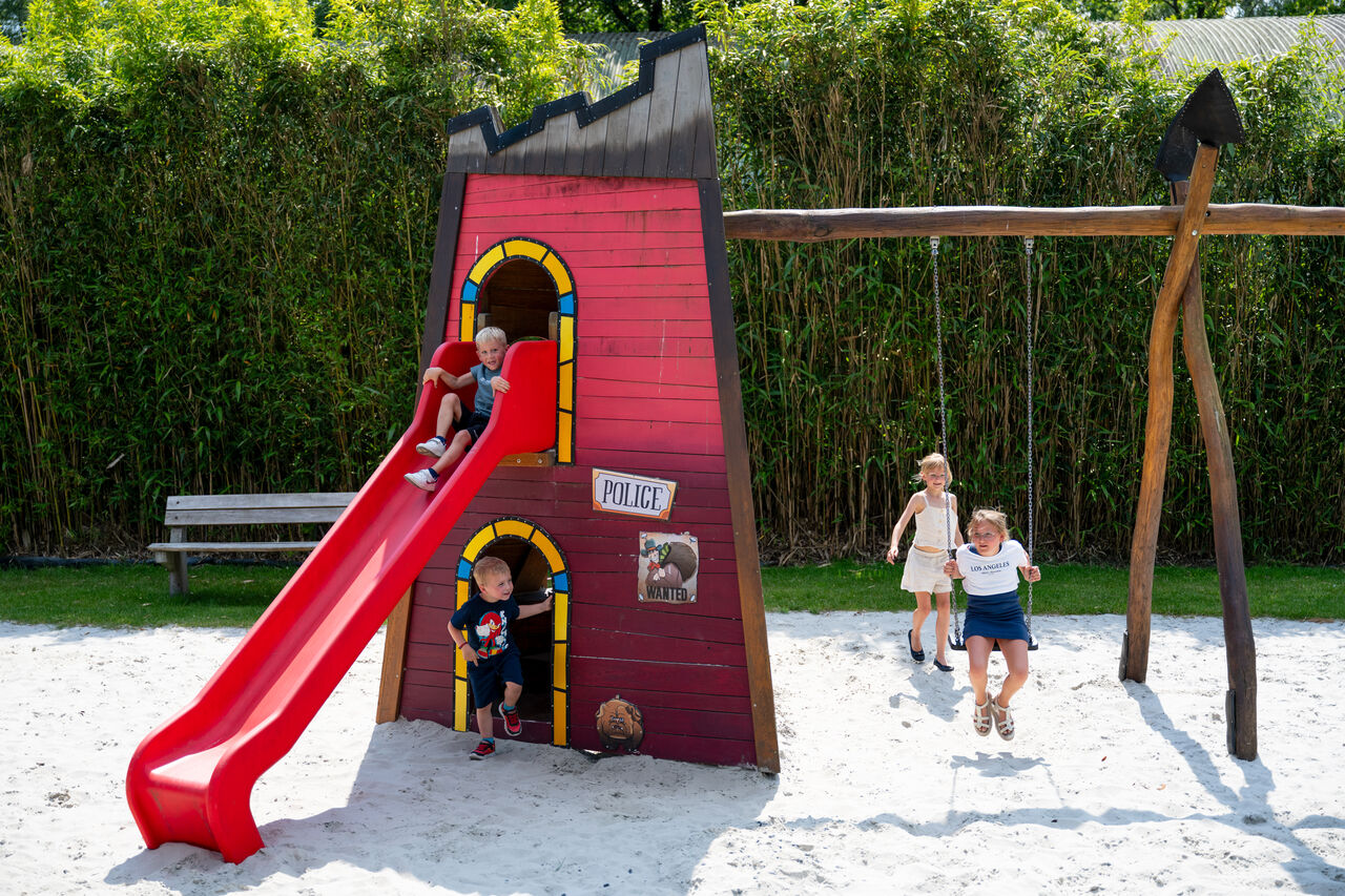 Aire de jeux avec toboggan et balan�oires pour enfants au camping CAPFUN Fort Bedmar � Sint-Gillis-Waas.