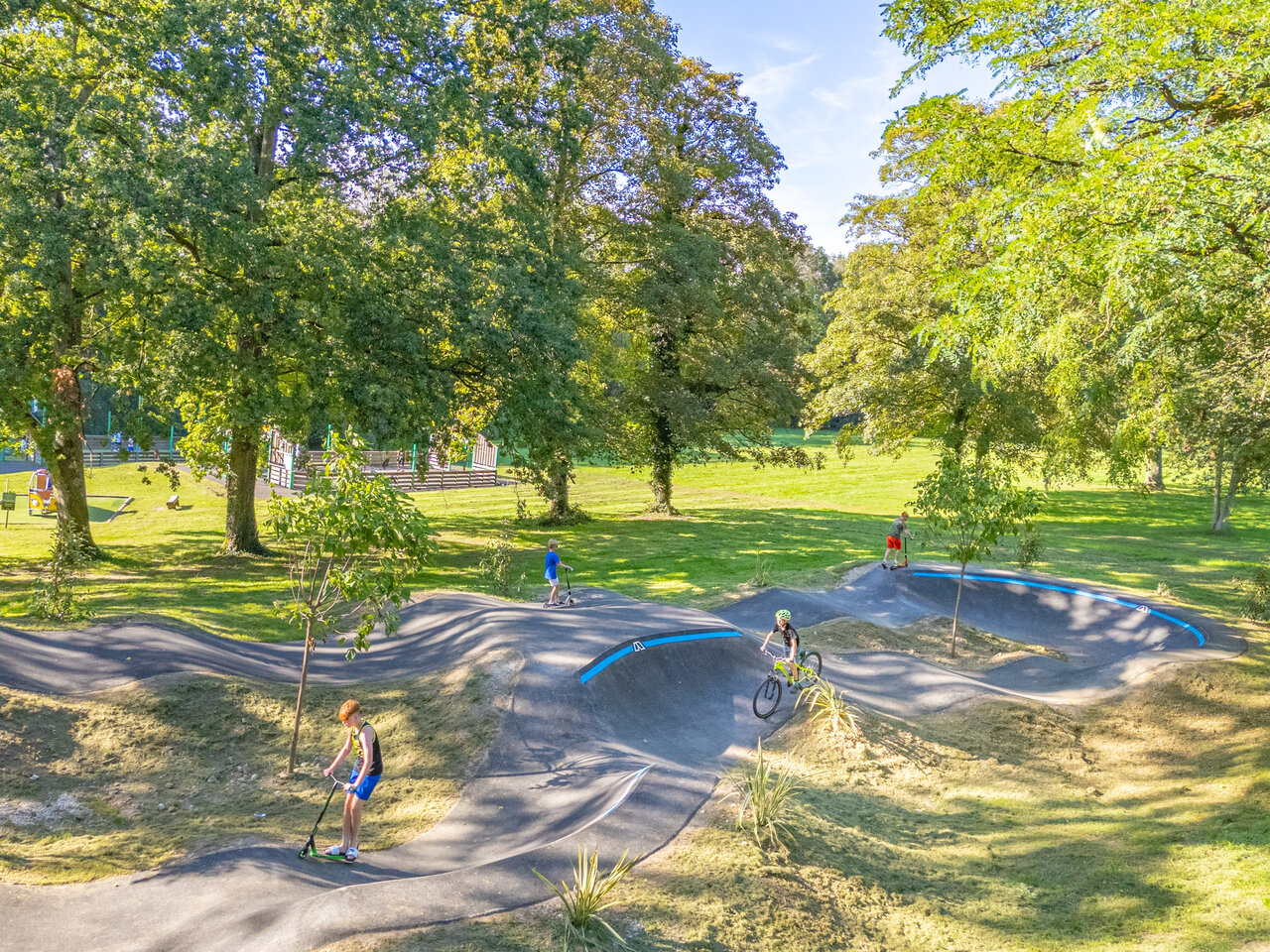 Modern pump track with children on scooters and bike at CAPFUN Fredland campsite in Tournan en Brie (77).
