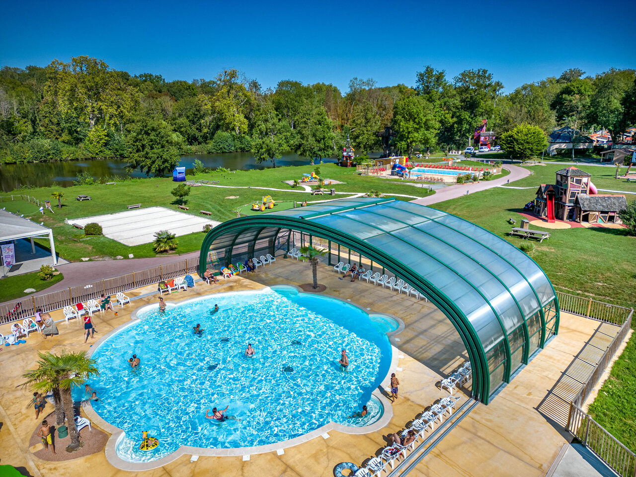 Covered and outdoor pool, playground at CAPFUN Fredland campsite (77).