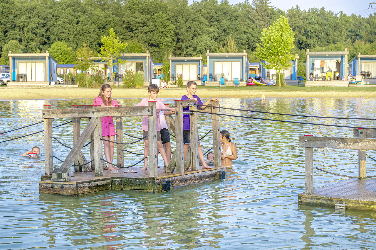 Enfants jouant sur plateforme flottante dans lac, h�bergements au camping CAPFUN De Fruithof � Klijndijk.
