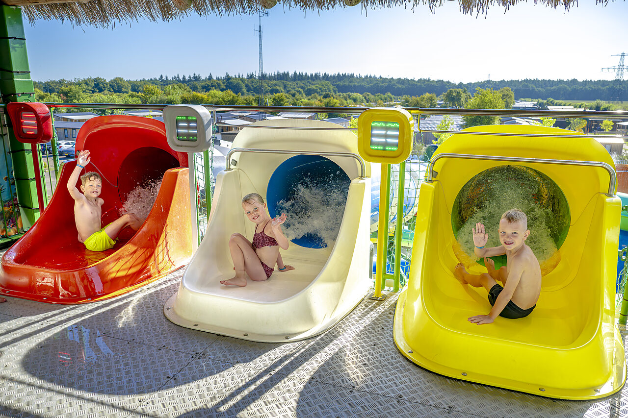 Enfants souriants sur les toboggans aquatiques color�s au camping CAPFUN De Fruithof � Klijndijk.