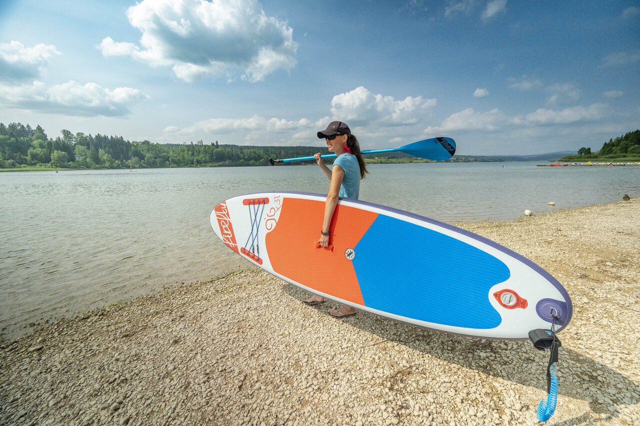 Femme avec paddleboard et pagaie au lac, camping CAPFUN Fuvettes � Malbuisson.