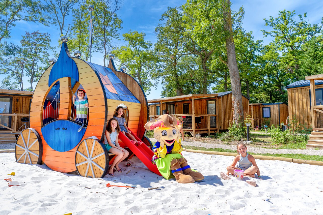 Aire de jeux avec toboggan, enfants et mascotte Brave au camping CAPFUN Grenouill�re � Su�vres (41).