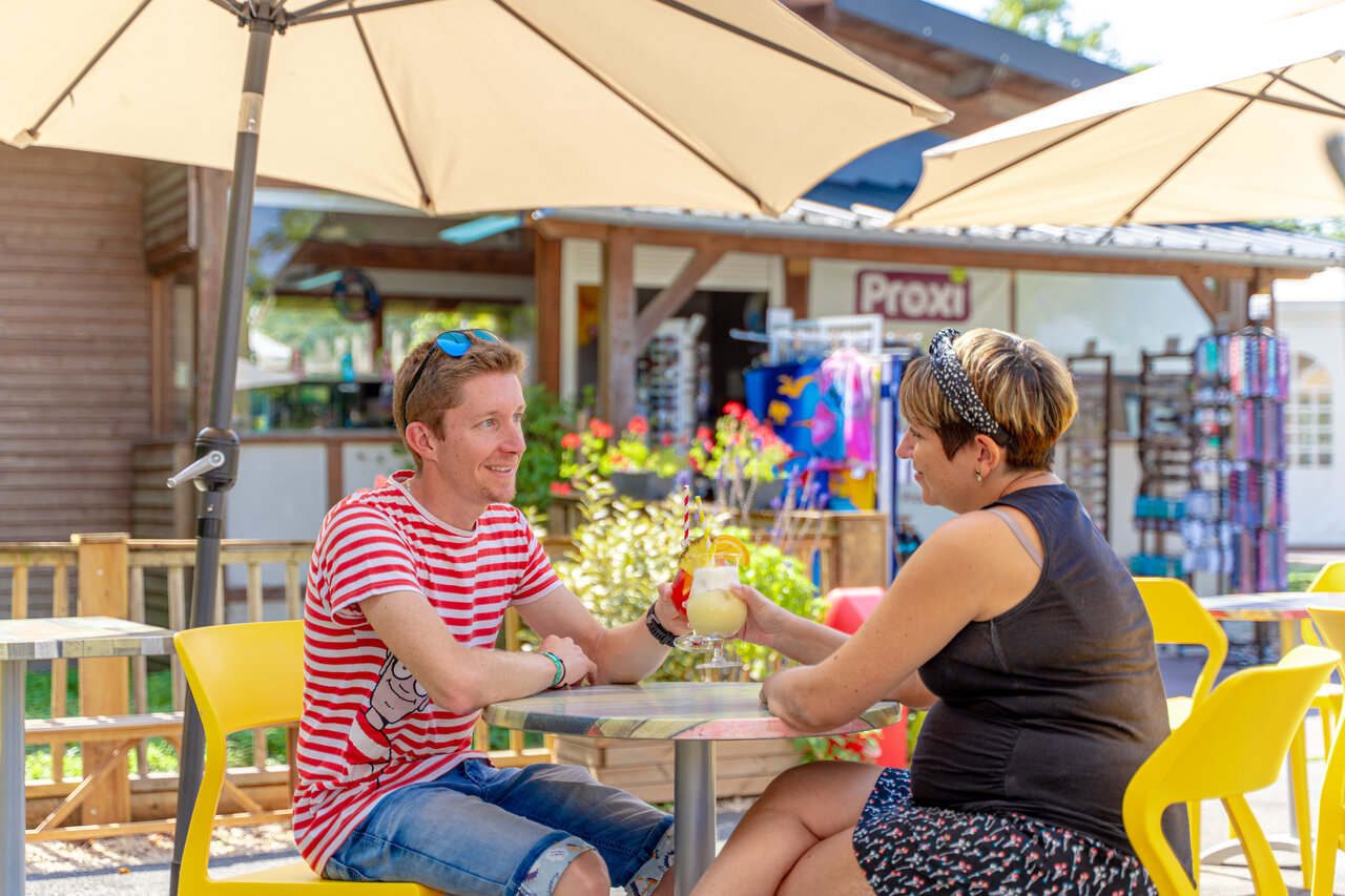Couple d�gustant cocktails sur terrasse bar-�picerie, camping CAPFUN Grenouill�re (41).