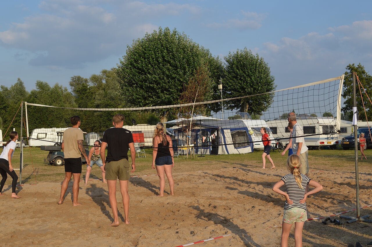 Joueurs de beach-volley sur terrain de sable au camping CAPFUN Groene Eiland � Appeltern.