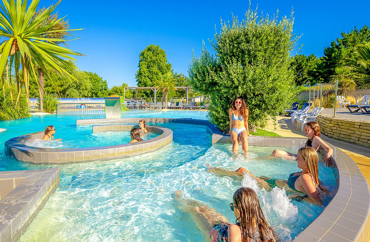 Piscine ext�rieure avec rivi�re et jacuzzi, jeunes femmes au camping VAGUES OCEANES Grosses Pierres � Saint-Georges-d'Ol�ron (17).