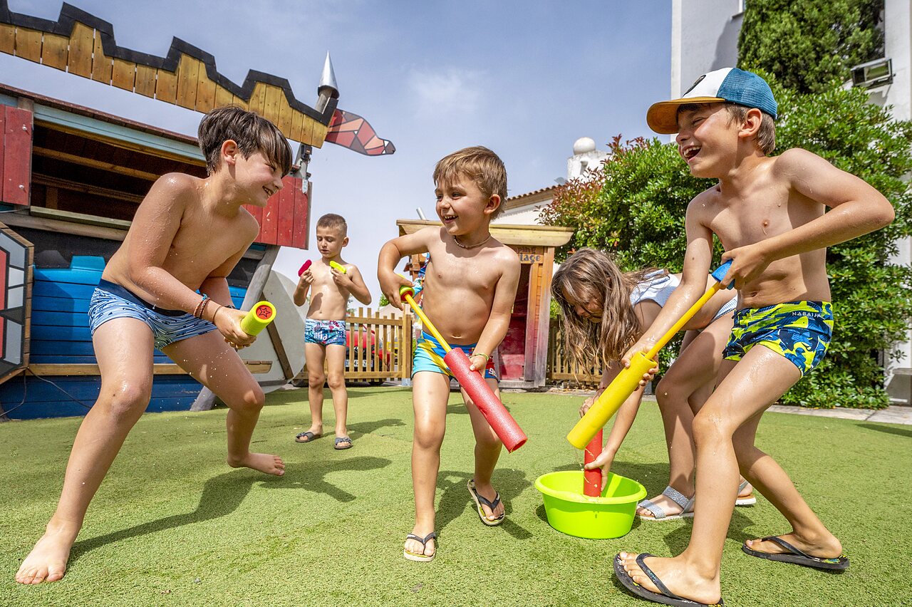 Enfants jouant pistolets � eau, aire de jeux, camping CAPFUN Hermitage SERIGNAN (34).