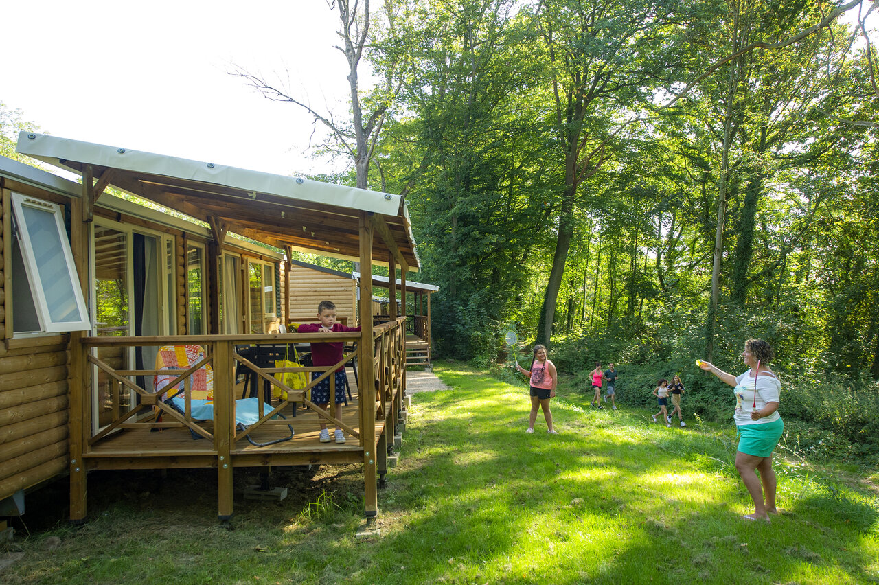 Mobile home en bois, enfants jouant au badminton au camping CAPFUN Hirondelle � Oteppe.