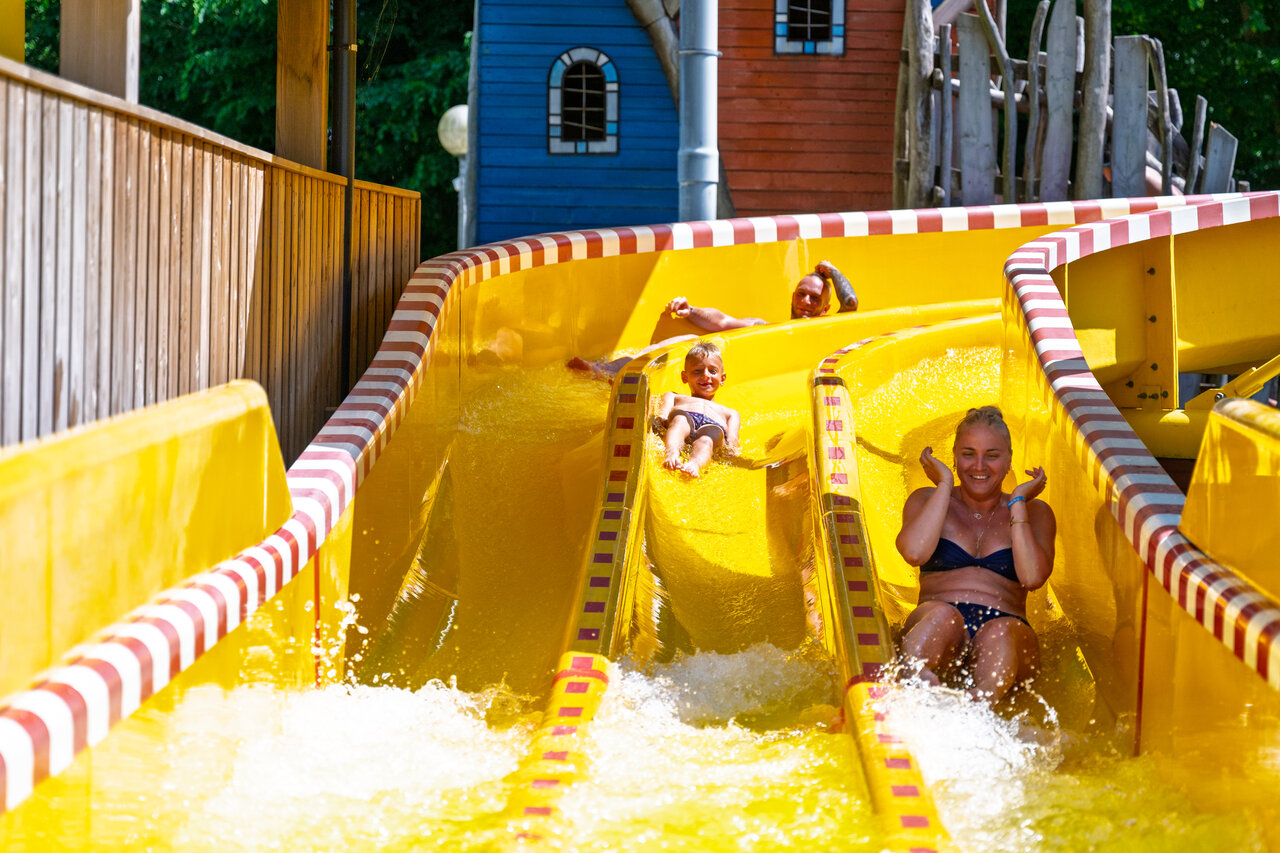 Famille s'amusant sur le toboggan aquatique jaune au camping CAPFUN Hirondelle � Oteppe.