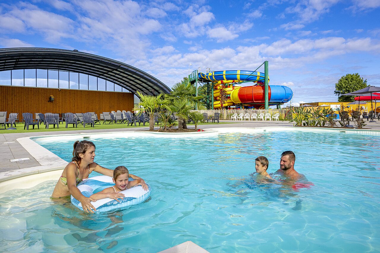 Famille dans la piscine ext�rieure avec toboggans g�ants au camping CAPFUN IJsselstrand � Doesburg.