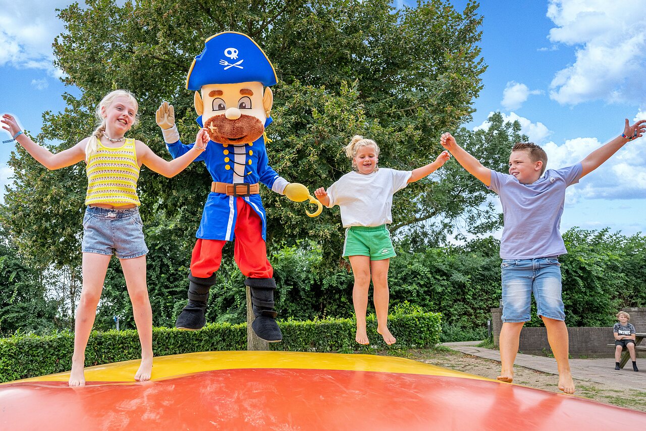 Enfants et mascotte pirate sautant sur coussin gonflable au CAPFUN IJsselstrand � Doesburg