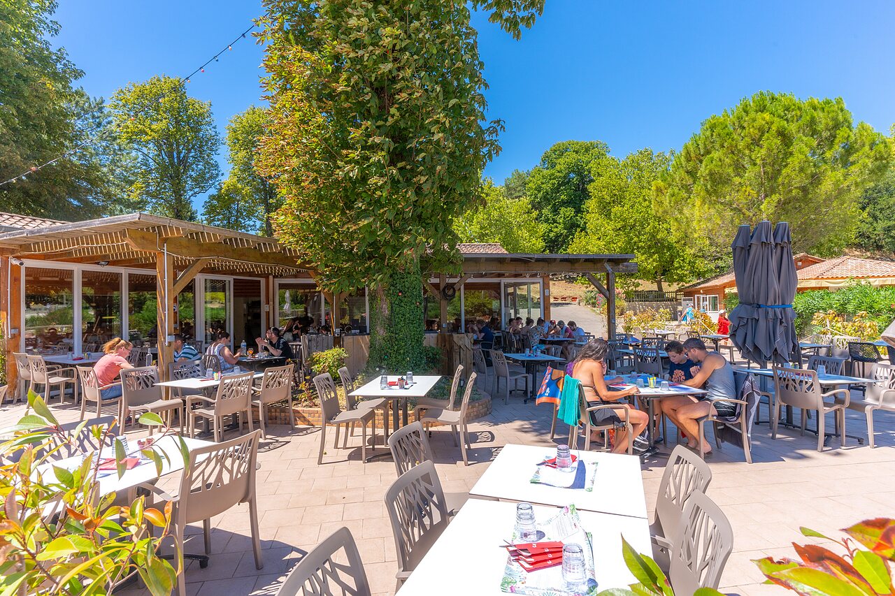 Terrasse de restaurant ext�rieure anim�e, repas en famille au camping CAPFUN Imbours � LARNAS (07).
