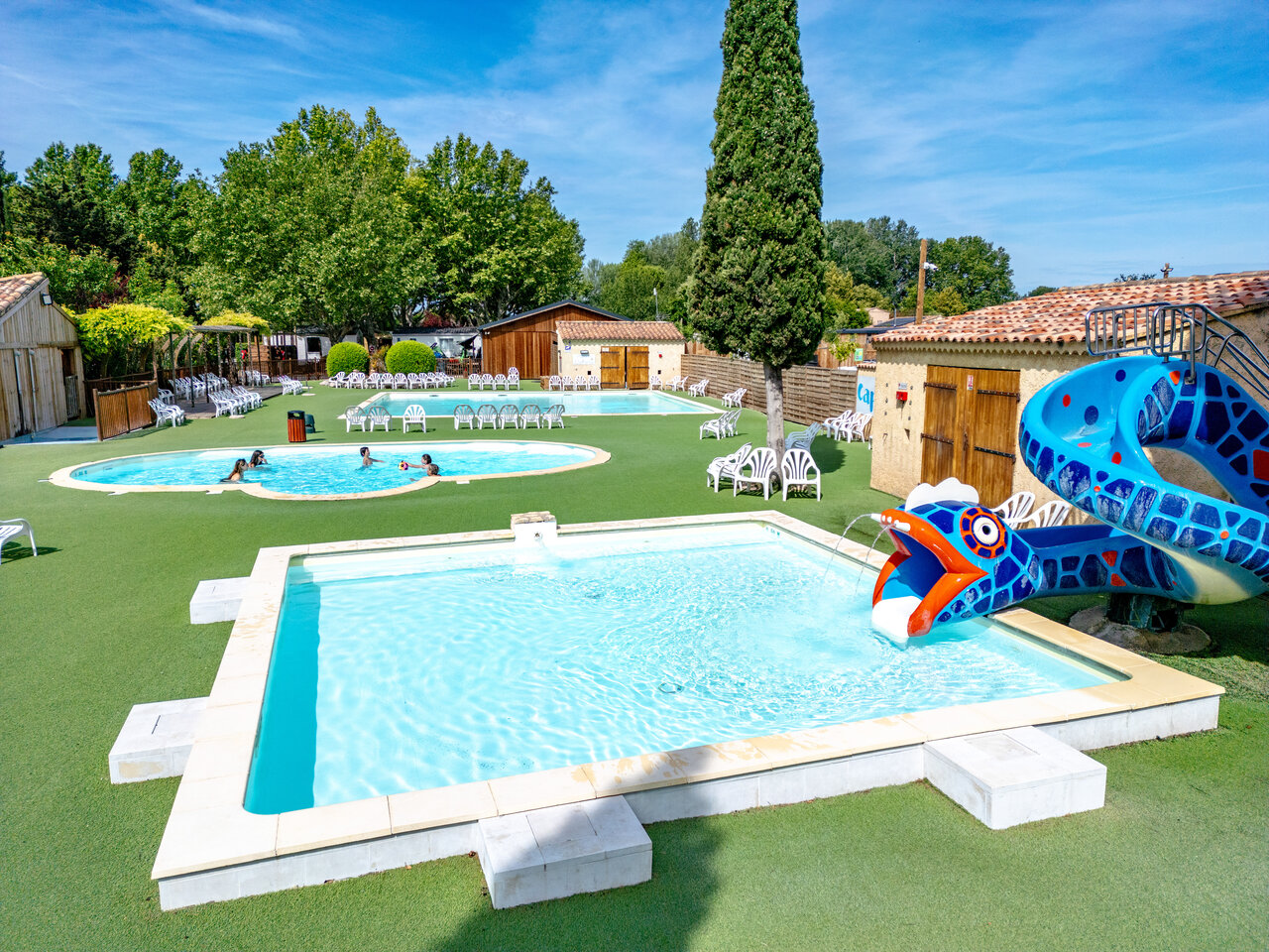 Piscines ext�rieures avec toboggan serpent et transats au camping CAPFUN Jantou � LE THOR (84).