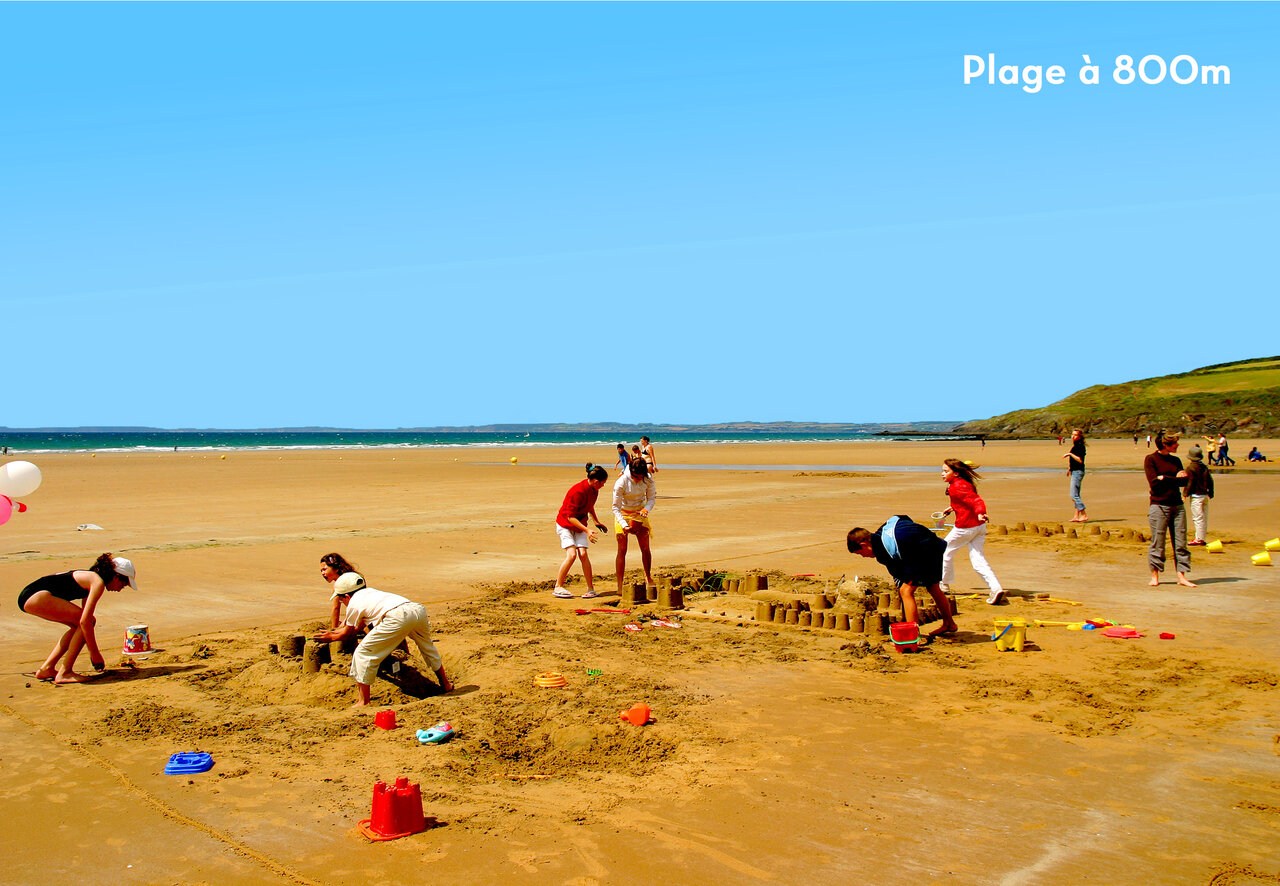 Familles construisant ch�teaux de sable sur la plage au camping CAPFUN Kervel � PLONEVEZ PORZAY.