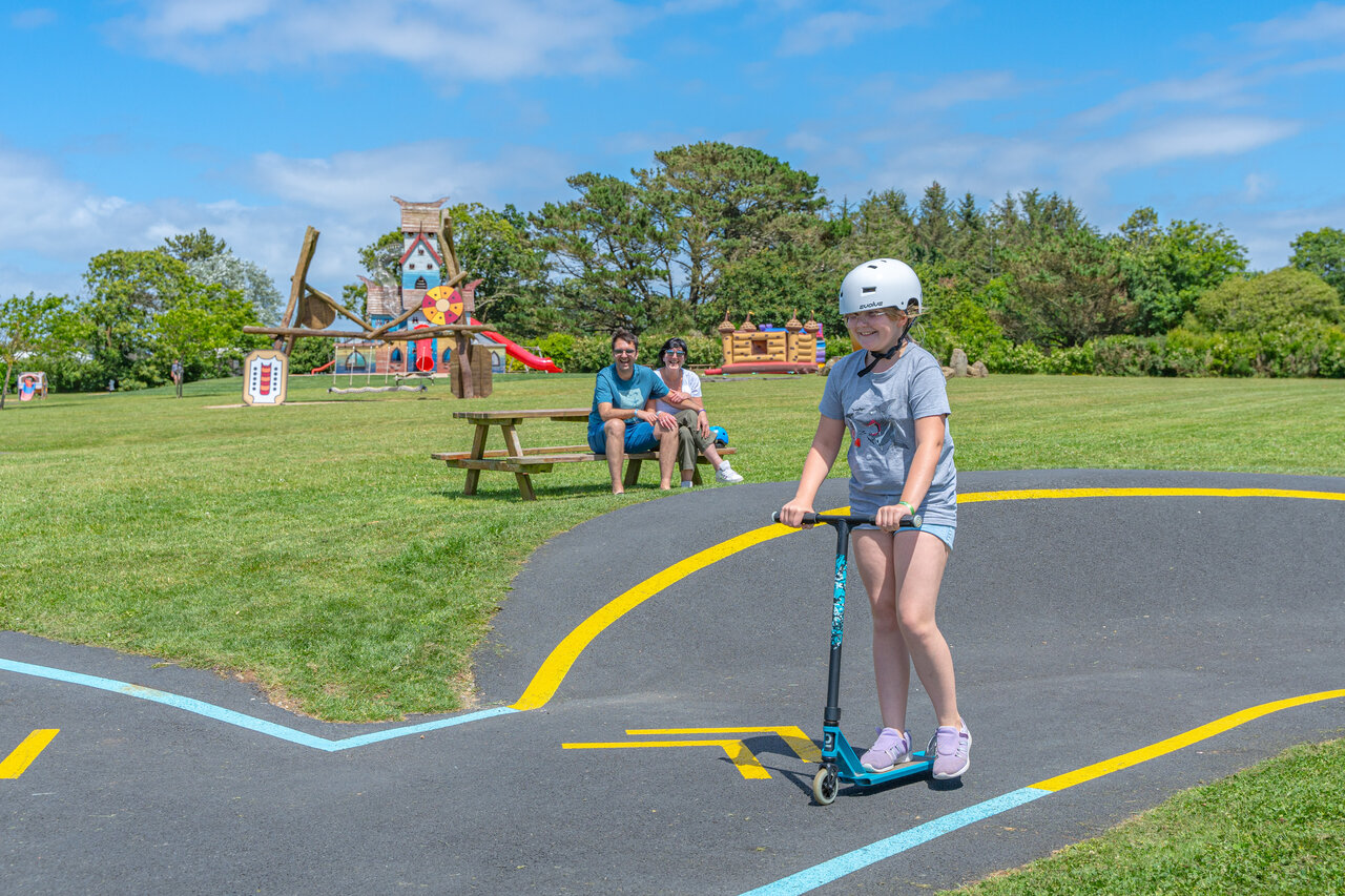 Enfant sur trottinette sur pumptrack, aire de jeux CAPFUN Kervel, PLONEVEZ PORZAY (29).